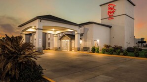 Un hotel Red Roof Inn con una estructura de dos pisos, entrada techada y estacionamiento.