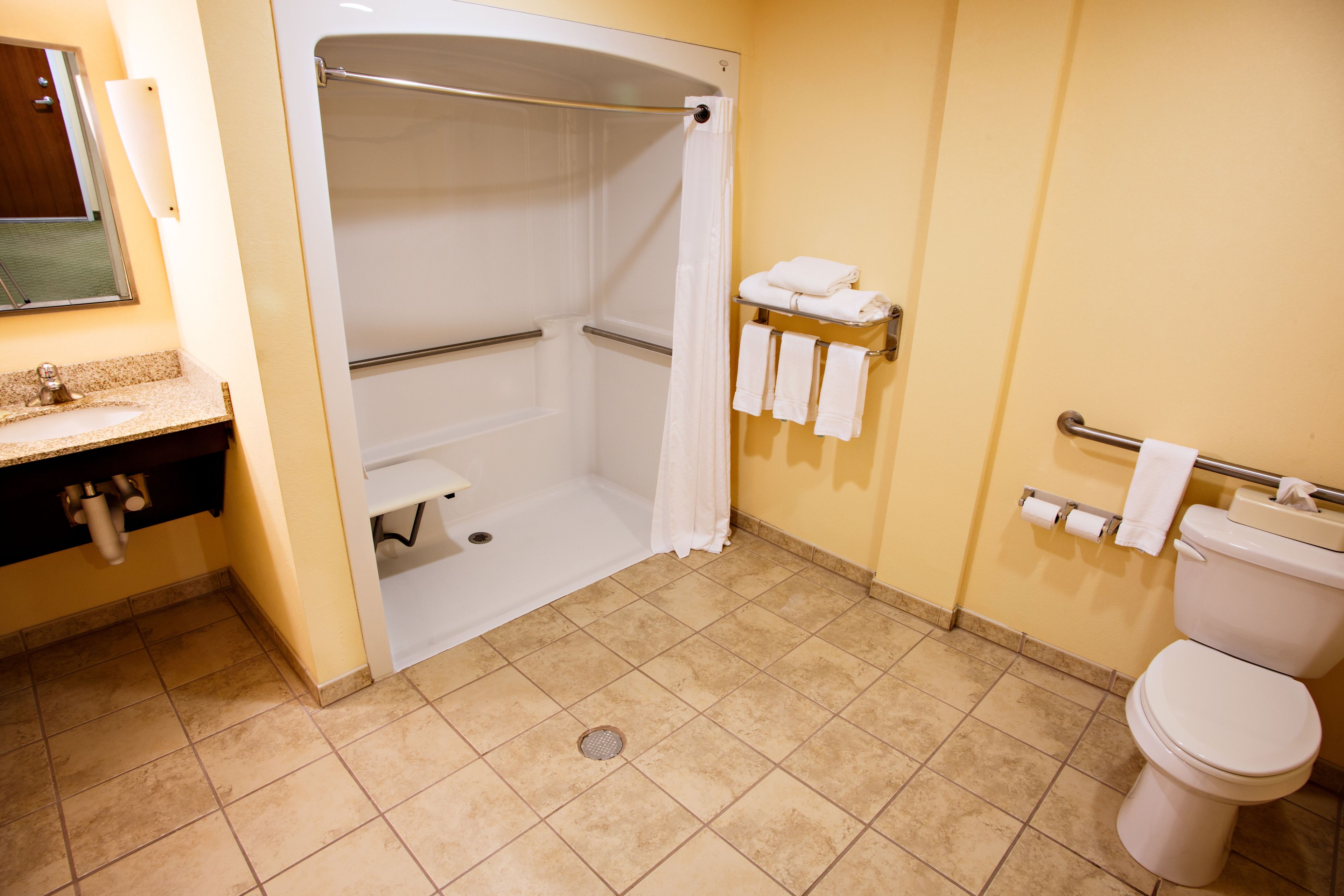 A bathroom with a shower, toilet, and sink.