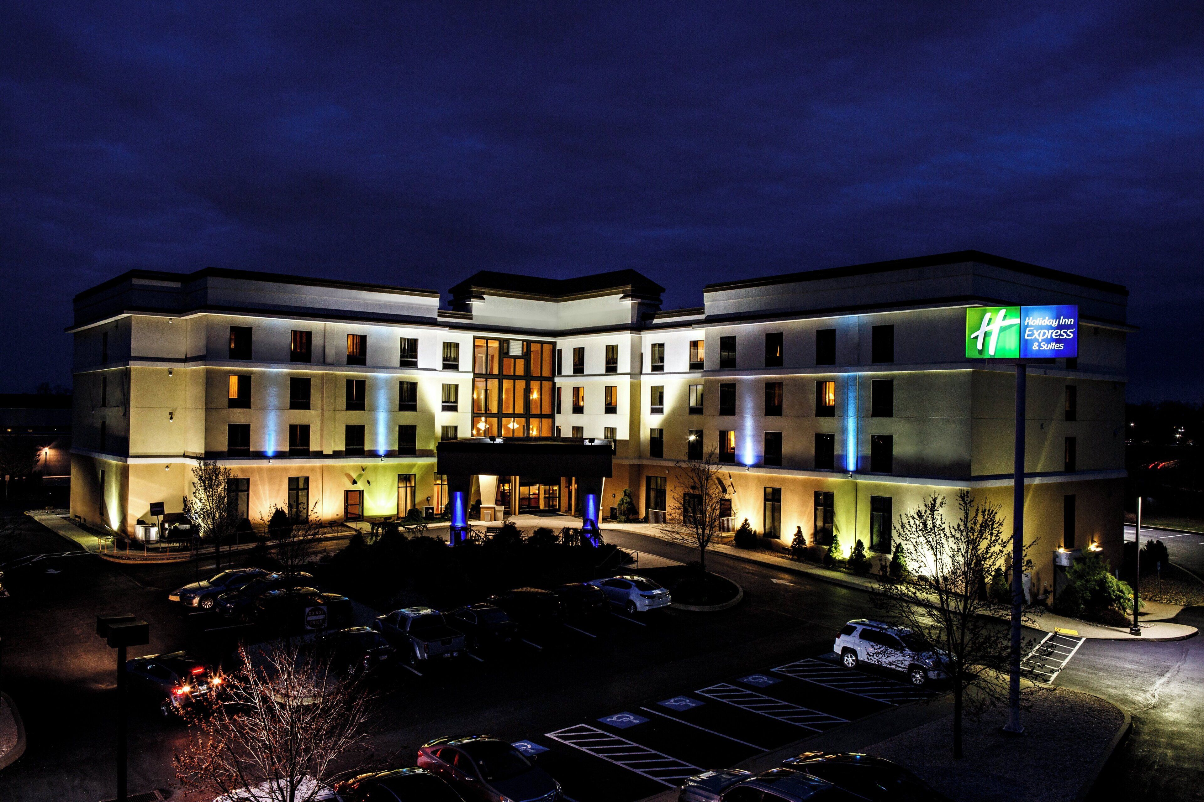 Un hotel Holiday Inn Express dal design moderno, con diversi posti auto e un ingresso ben illuminato.
