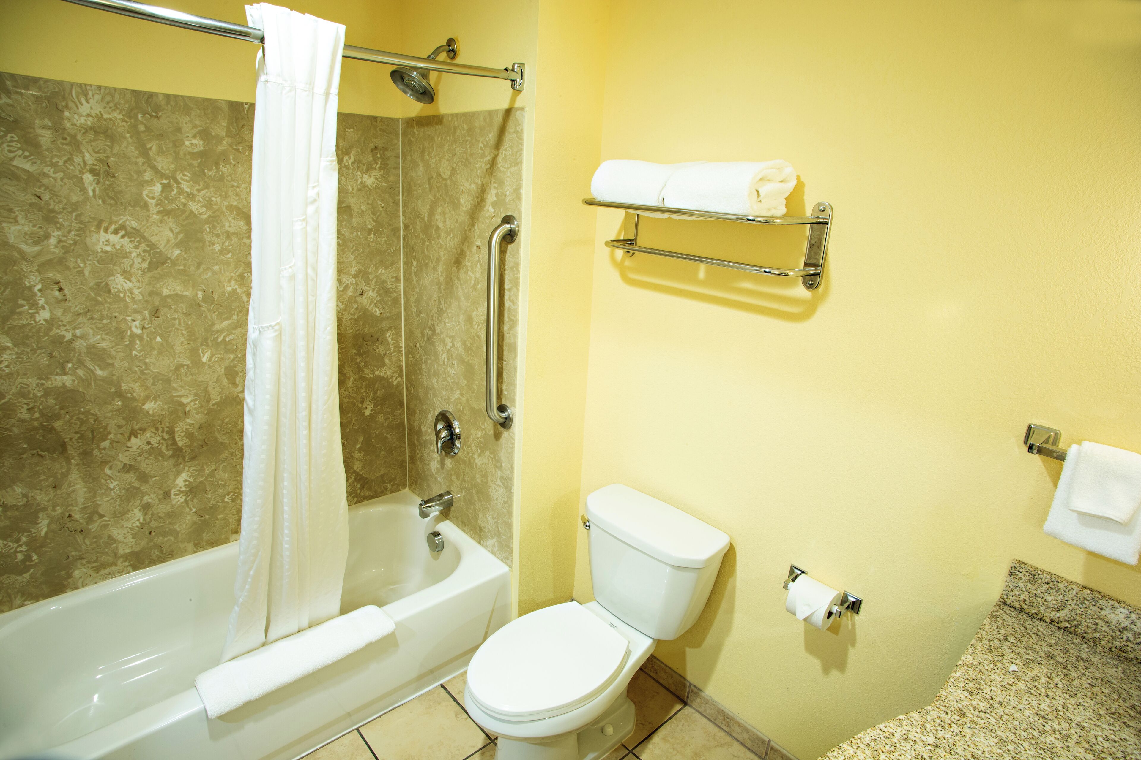 Ein Badezimmer mit Badewanne, Dusche, Toilette und Handtuchhalter.