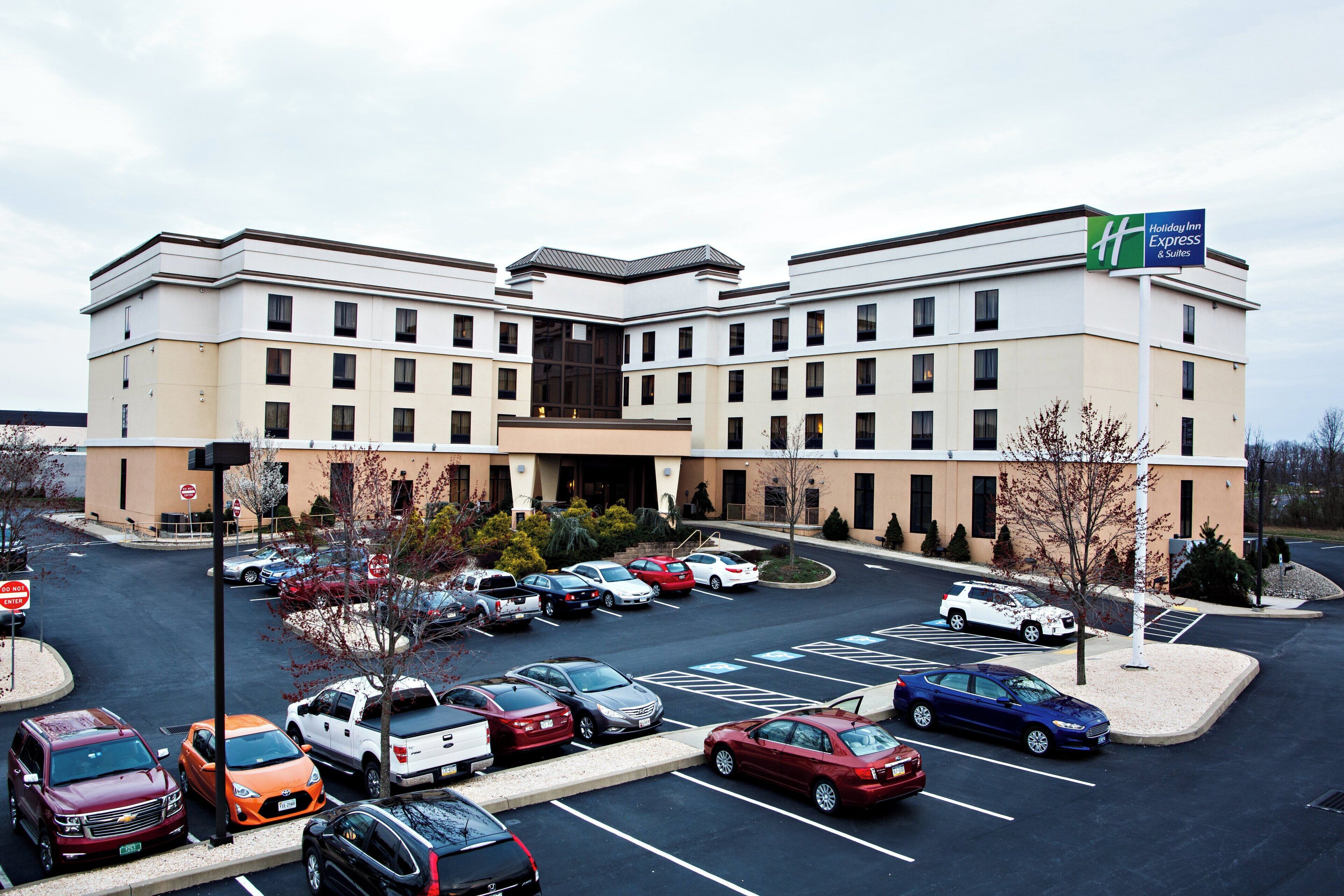 Un hôtel Holiday Inn Express avec un parking rempli de voitures.
