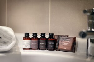 Casa de banho com quatro frascos de produtos Botanica e uma barra de sabão.