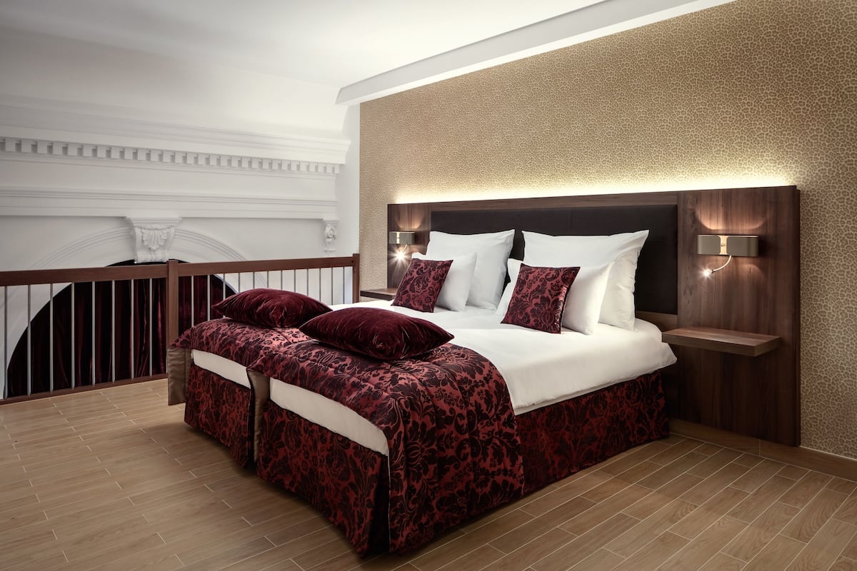 Un dormitorio moderno con una cama grande, un cabecero de madera y una mesita de noche con una lámpara.