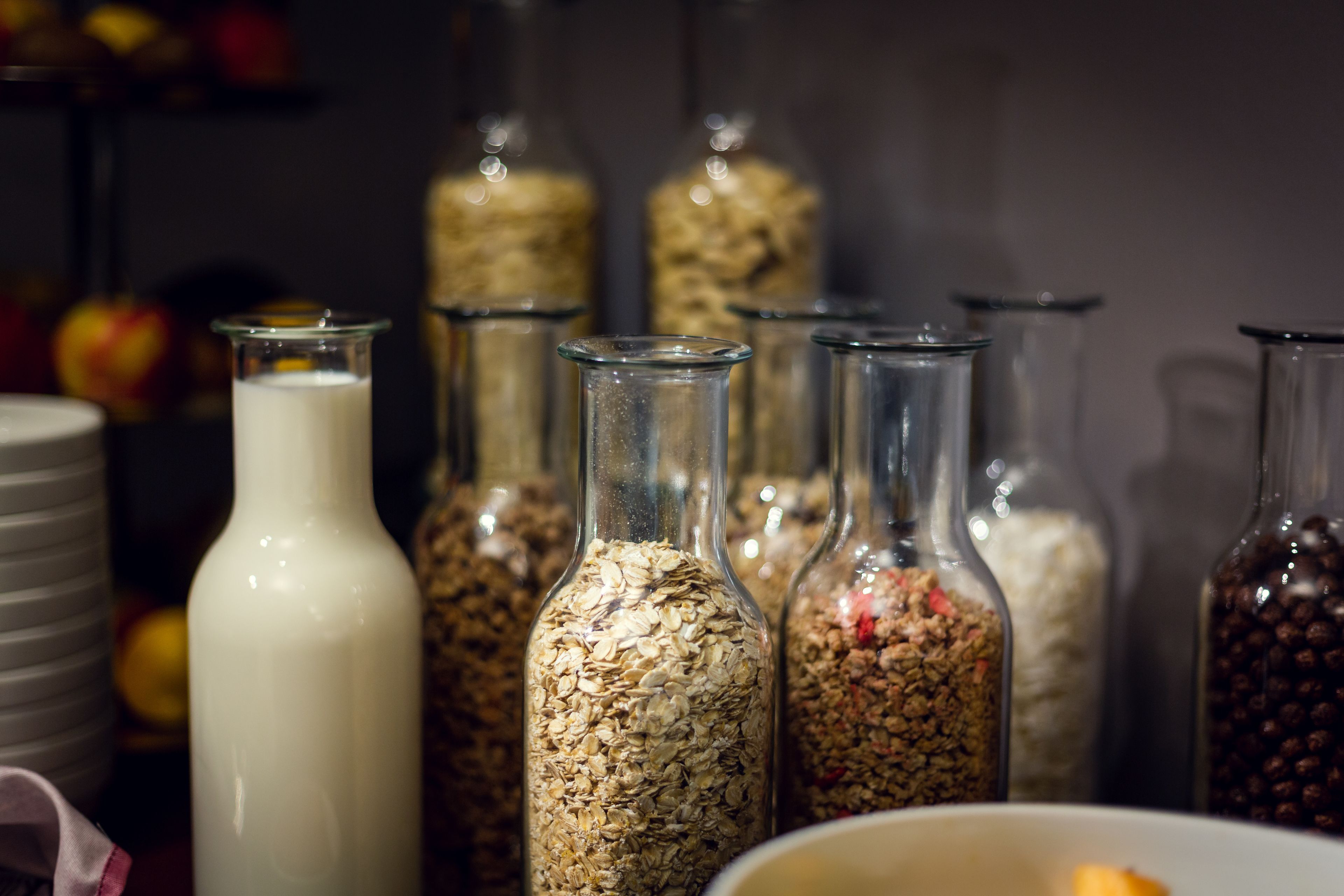 A variety of glass containers filled with different food items, likely in a kitchen or storage area.