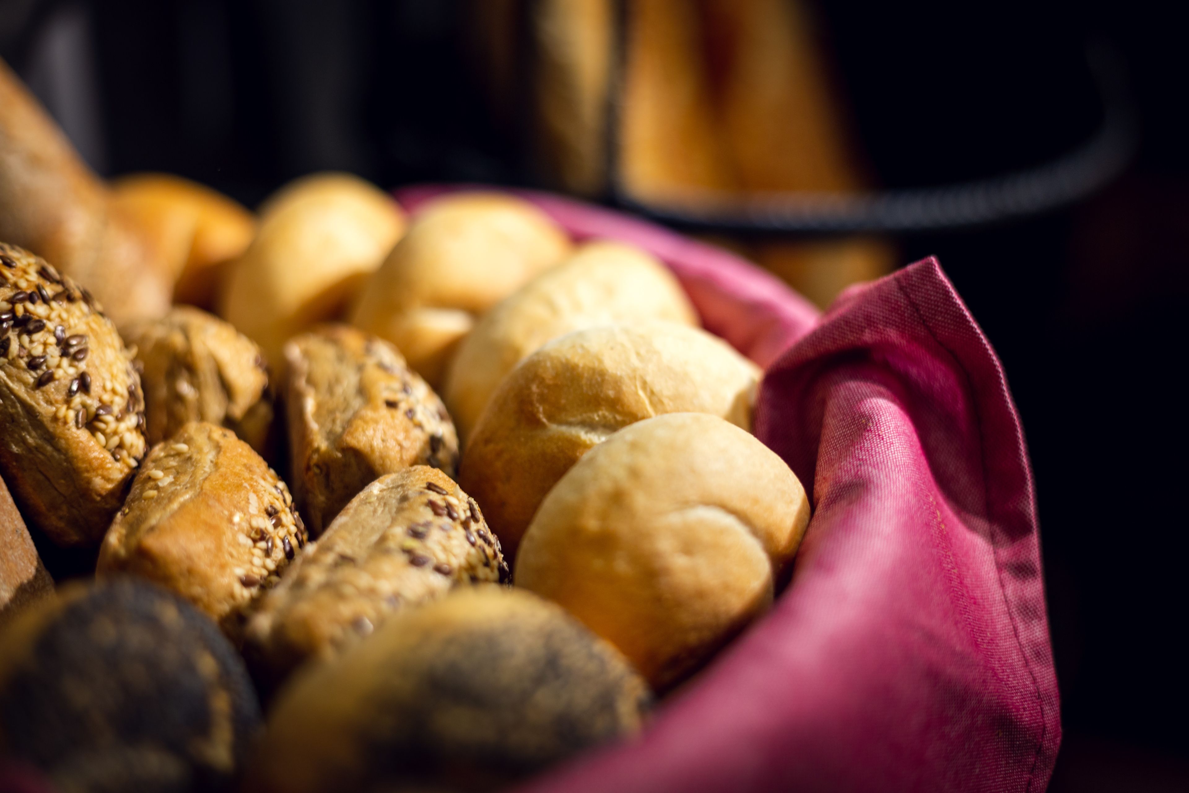 A basket of various baked goods, including bread rolls and pastries.