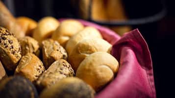 Una cesta con diversos productos de panadería, incluyendo bollos y pasteles.