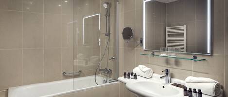 A modern bathroom with a bathtub, a sink, and a mirror.
