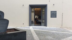 En modern entré till en byggnad med ett klinkergolv och en skylt som visar att det finns en restaurang och en vinbar här.