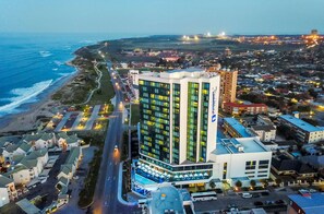Een hotel met een modern design, dichtbij een strand met uitzicht op de oceaan.