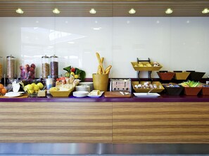 Mesa de buffet con diferentes alimentos y un tostador.