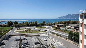 A multi-level parking structure with clear roadways and a view of the sea and mountains in the background. - Hotel Novotel Salerno Est Arechi (Salerno)