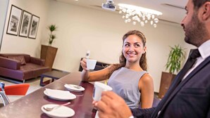 A modern dining area with a marble table, a sofa, and a chandelier. - Hotel Novotel Salerno Est Arechi (Salerno)