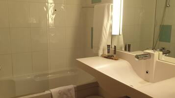 Un baño moderno con bañera, lavabo y espejo.