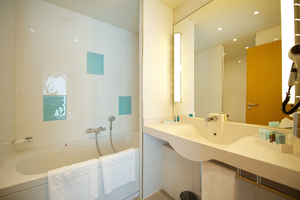 Un baño moderno con bañera, ducha y tocador con espejo.