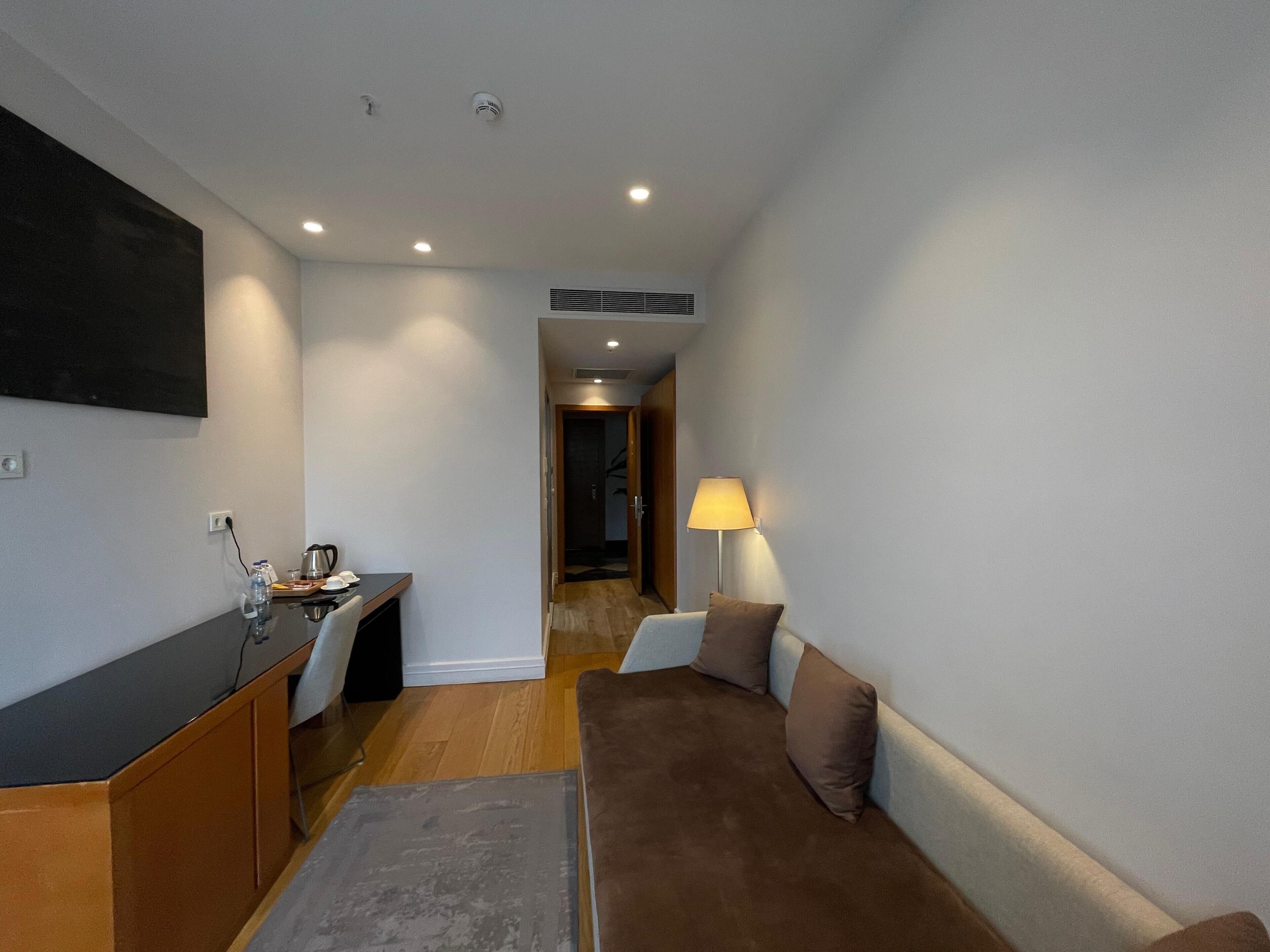 A modern living room with a sofa, a coffee table, and a TV mounted on the wall.