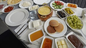 Un bufé de desayuno con diversos platos y aderezos sobre una mesa de mármol.