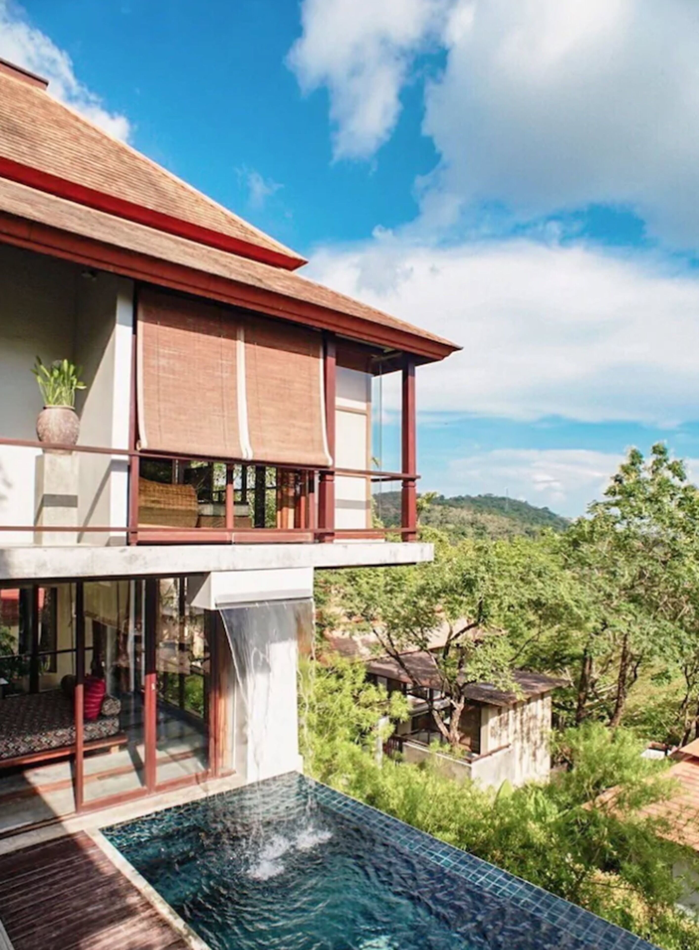 Ein modernes Haus mit großzügigem Balkon, Wasserspiel und Schwimmbecken.