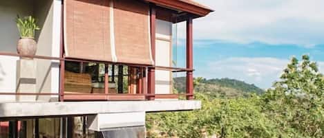 Ein modernes Haus mit großzügigem Balkon, Wasserspiel und Schwimmbecken.