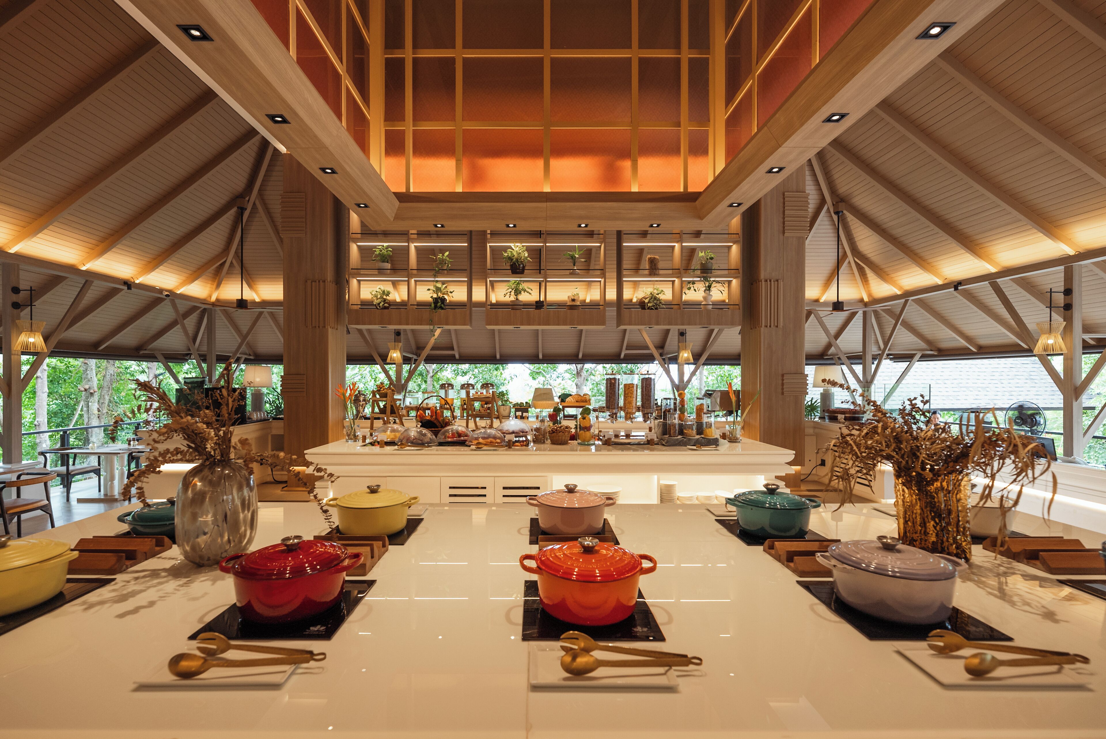 Una cocina amplia con una isla central, vigas de madera y vistas al exterior.