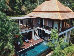 A modern two-story house with a swimming pool, outdoor seating, and a view of the surrounding forest. - Villa Zolitude Resort & Spa (Chalong)