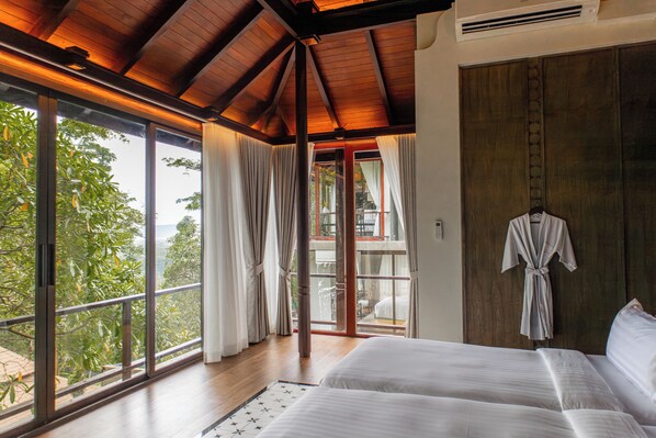 A bedroom with a large window, wooden ceiling, and a view of greenery. - Villa Zolitude Resort & Spa (Chalong)
