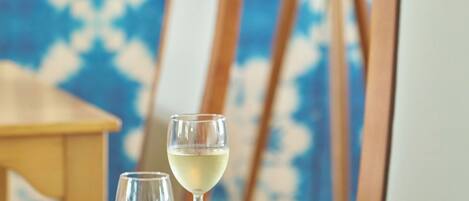 Une table avec une planche à fromages, des verres à vin et une assiette contenant une pâtisserie.