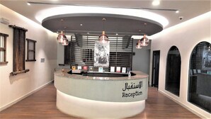 A reception area with a curved counter, modern pendant lighting, and a large poster on the wall.