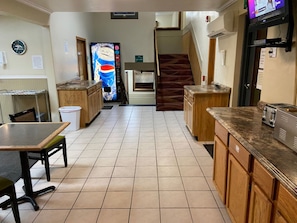 A kitchen with wooden cabinets, a tiled floor, a refrigerator, and a microwave. - Adventure Inn - Glenwood Springs  (Glenwood Springs)