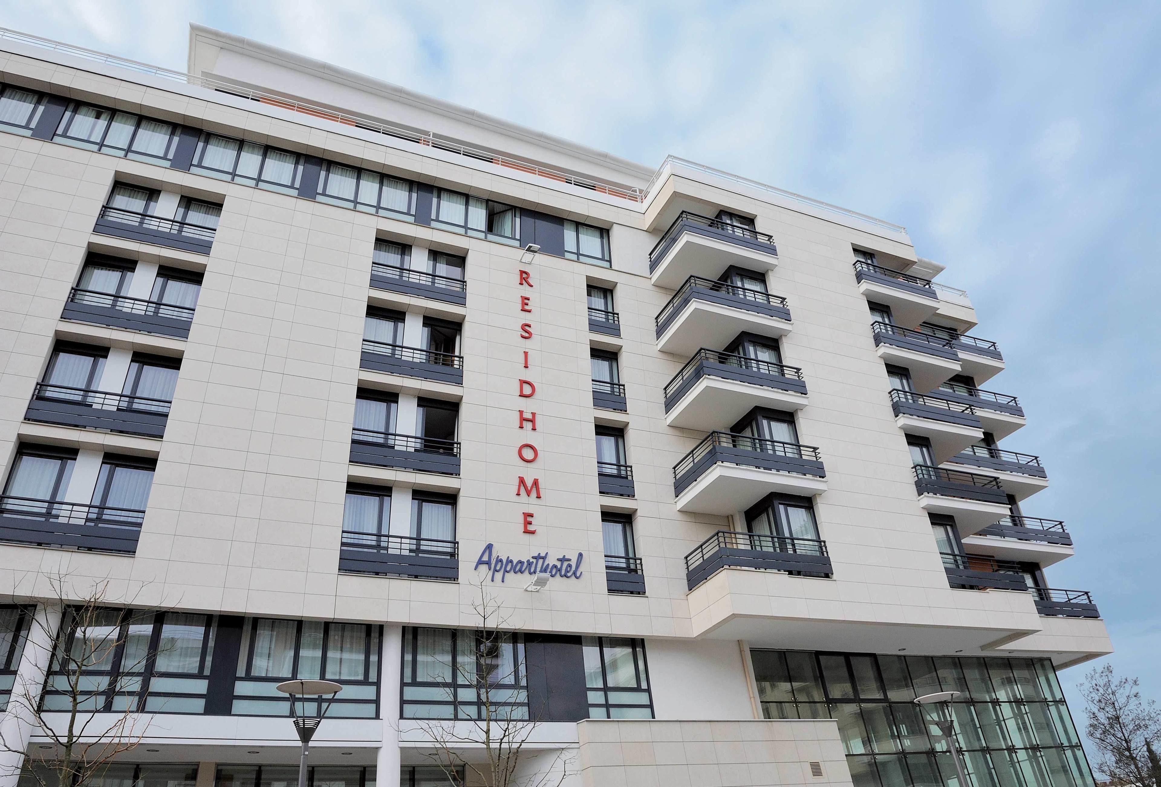 Un immeuble à plusieurs étages, portant les enseignes « RESIDHOME » et « Appartotel », ce qui indique qu’il s’agit d’un hôtel résidentiel.