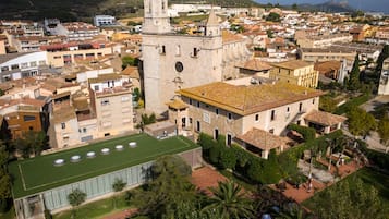 Uma cidade histórica com uma torre de igreja imponente, um edifício moderno com telhado verde e uma mistura de edifícios residenciais e comerciais.