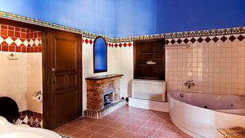 Un baño con una bañera grande, ducha, puerta de madera y un espejo.