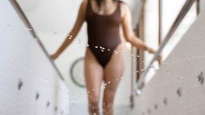 A person in a swimsuit walking down a hallway with a stone floor. - Hotel Manantial- Balneari Caldes de Boi (La Vall de Boi)