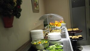 A buffet setup with various food items and a Christmas tree. - Castelli Hotel (Nicosia)