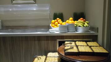 Ein Buffet mit verschiedenen Speisen, darunter Obst, Gemüse und Desserts.