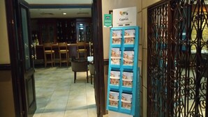 A hotel lobby with a reception desk, seating area, and a display of Cyprus travel guides. - Castelli Hotel (Nicosia)