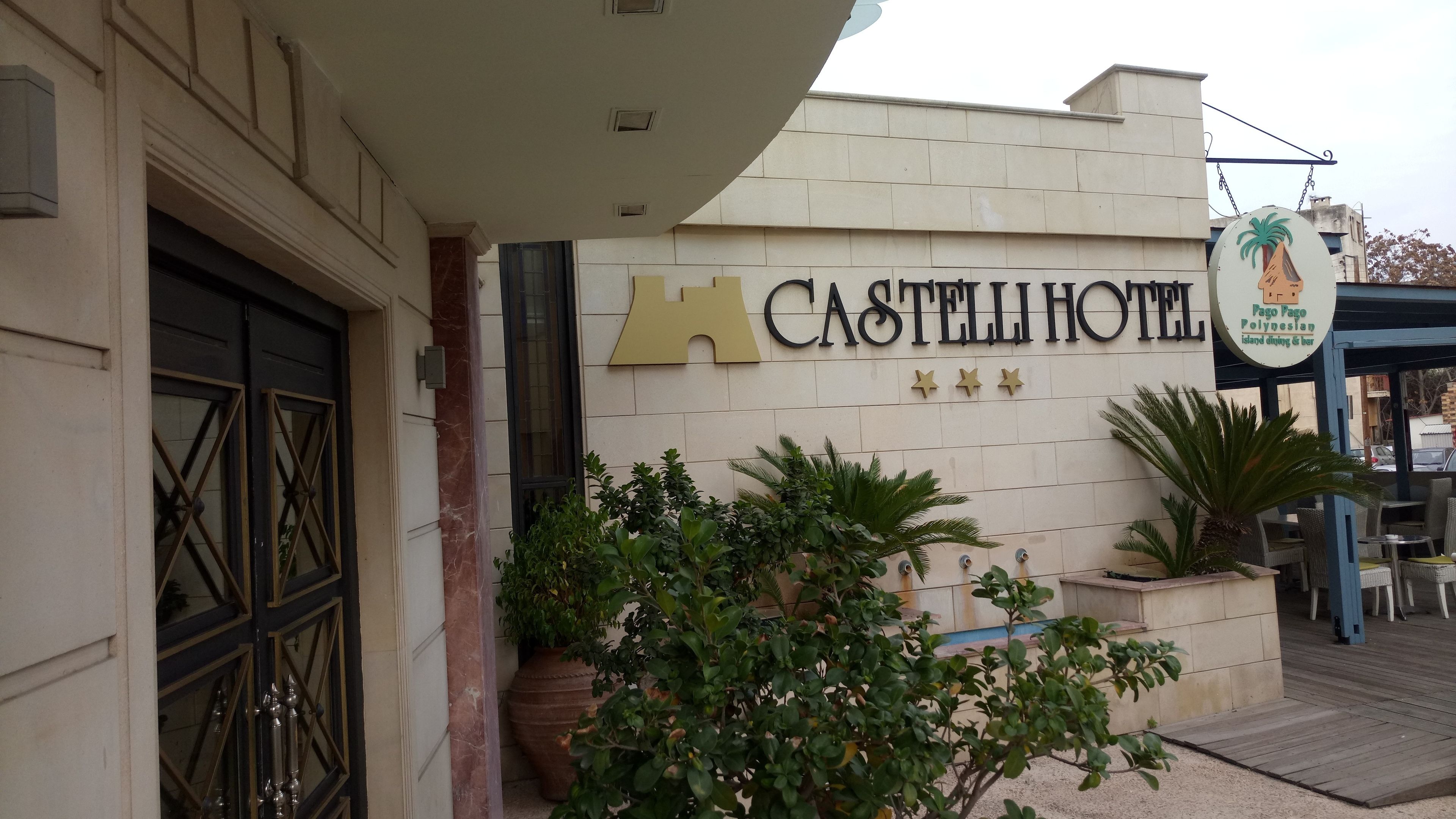 The exterior of Castell Hotel with a sign indicating a restaurant named Pago Pago Polynesian island dining & bar.