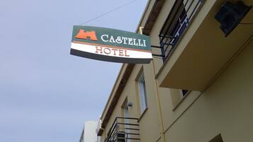 A hotel sign with the name "CASTELLI HOTEL" and a mountain icon.