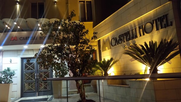 The exterior of Castellini Hotel with a prominent entrance, a large potted plant, and a well-lit facade. - Castelli Hotel (Nicosia)
