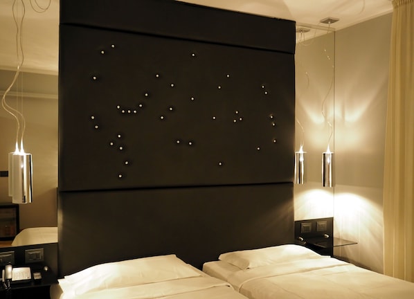 A modern hotel room with a large bed, bedside tables, a wall-mounted light fixture, and a mirror. - Hotel Corte Ongaro (Verona)