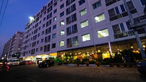 A multi-story hotel with a ground-level restaurant and parking area. - Centric Place Hotel (Bangkok)