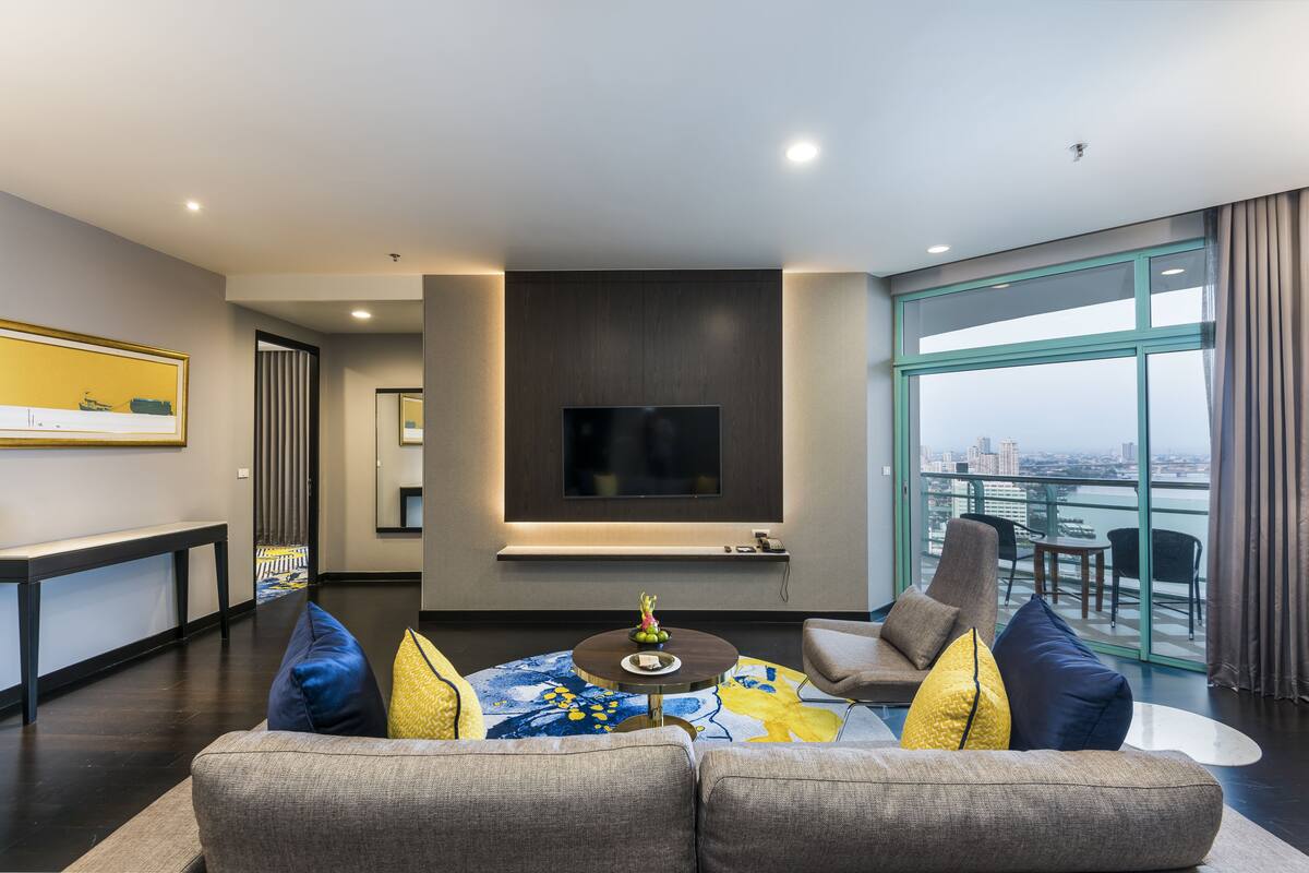 Un salon moderne avec un canapé, une table basse et un téléviseur fixé au mur.