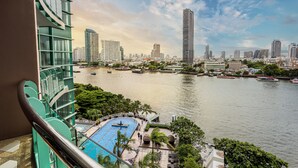Un hotel de gran altura con piscina y vistas a la silueta urbana y un cuerpo de agua.