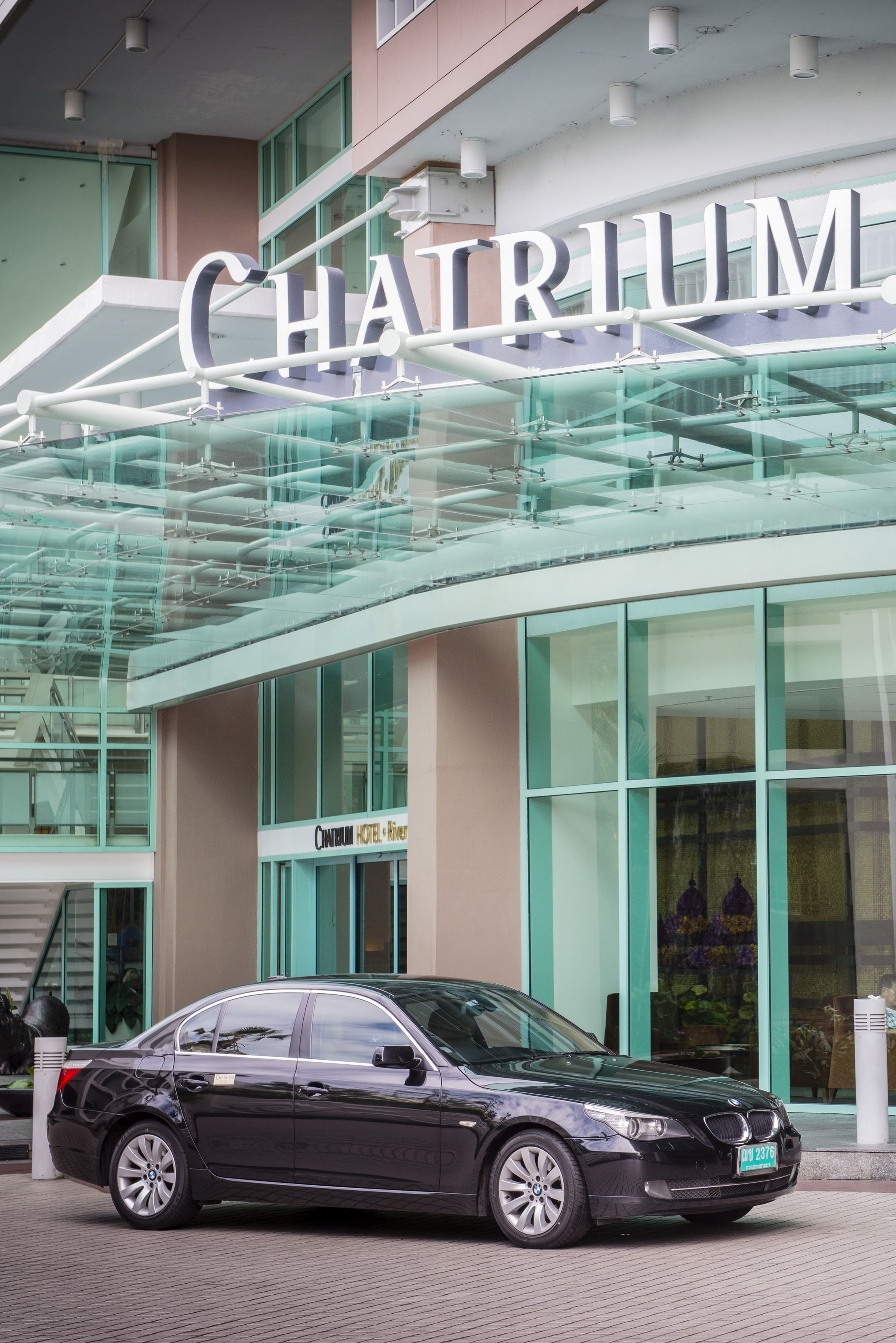 A modern building with a glass facade and the sign "CHATRIUM HOTEL".