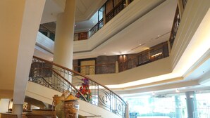 Un atrium à plusieurs niveaux, doté d’un grand escalier, de larges colonnes et d’un hall d’entrée spacieux.