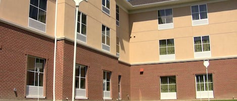 Un edificio de varios pisos con fachada de ladrillo y numerosas ventanas.