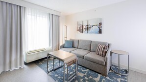 Una sala de estar moderna con un sofá, una mesita, un radiador y un tapete estampado.
