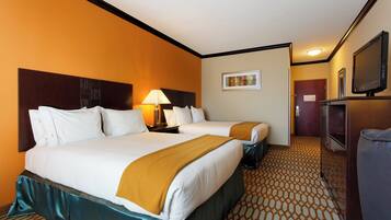 A hotel room with two beds, a television, a lamp, and a painting on the wall.