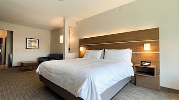 A hotel room with a large bed, bedside tables, a desk, and a chair.