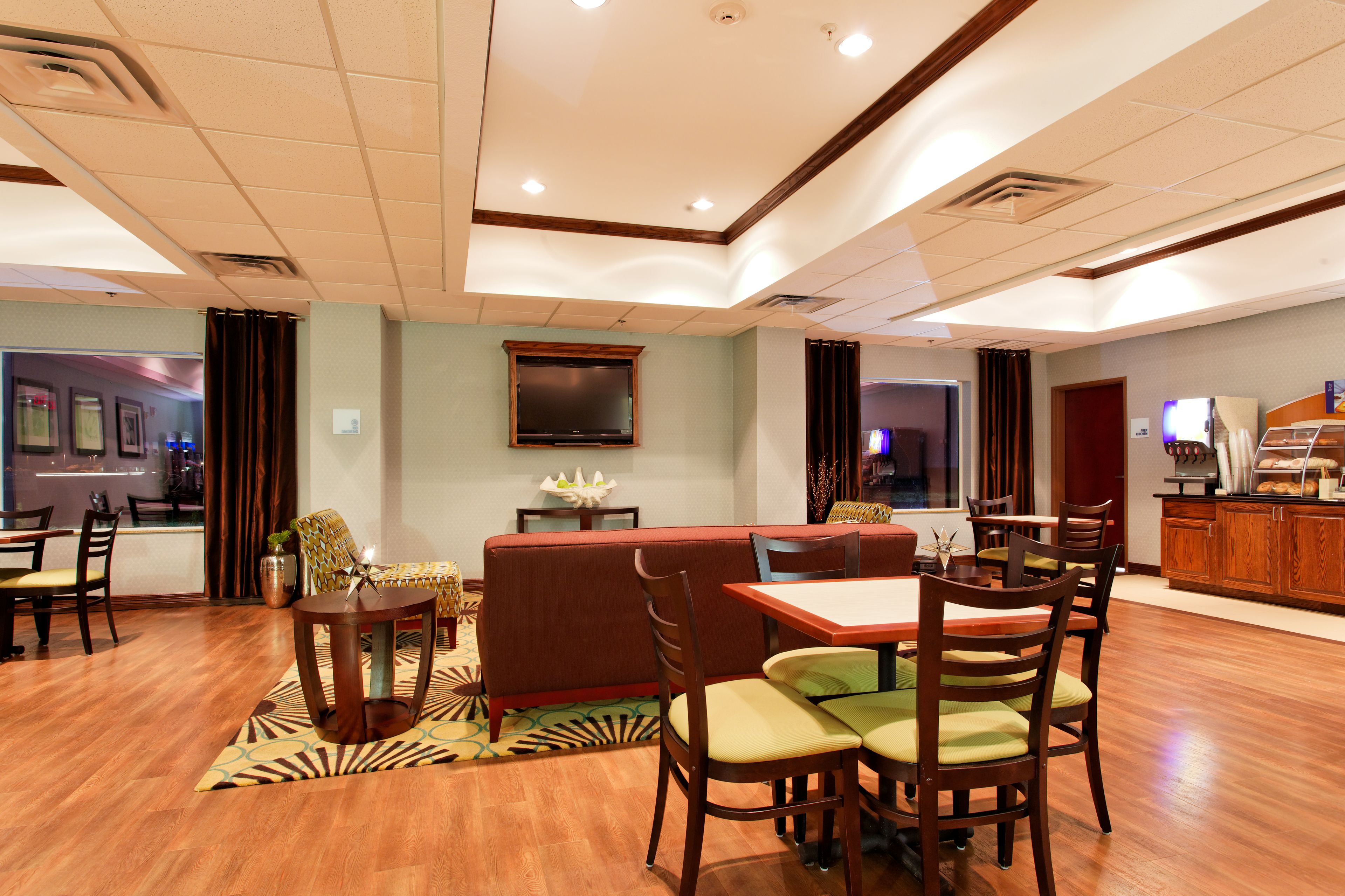 Un comedor de hotel con una cabina, una mesa con sillas y una zona de cocina con bufé.