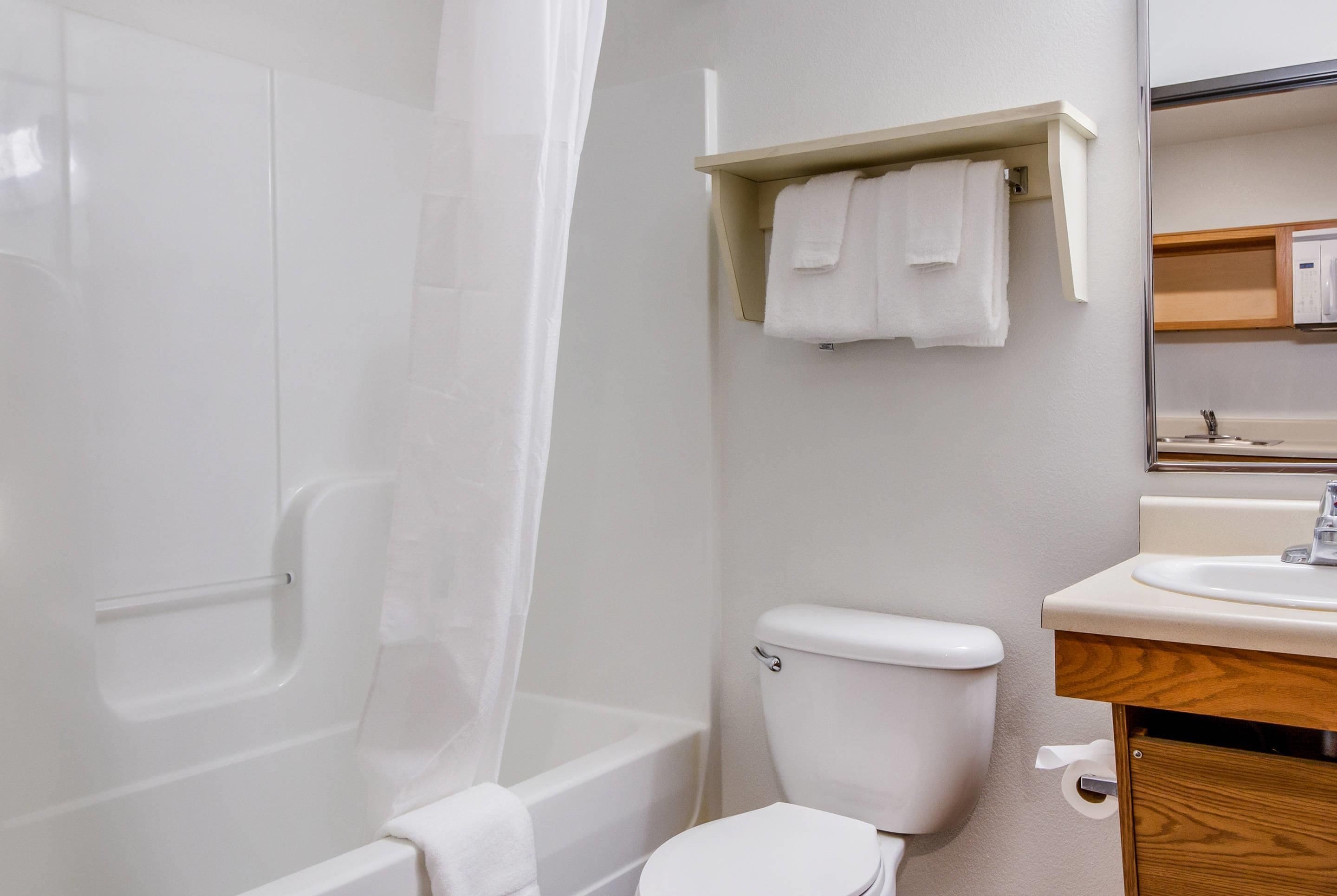 A bathroom with a bathtub, toilet, and a sink.